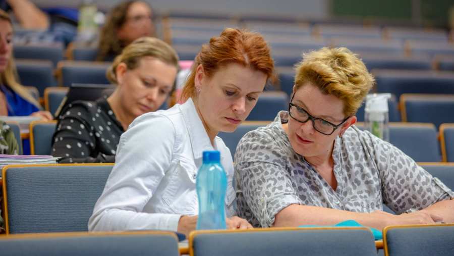 twee studenten overleggen tijdens hoorcollege